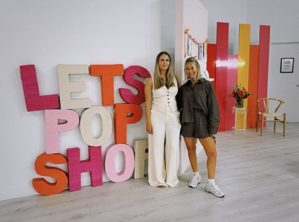 Let's pop shop event showing signage and backdrops with the event organizer and a vendor