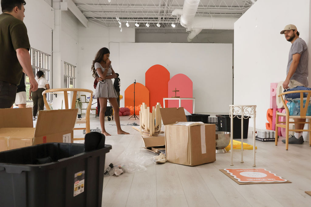 Wide room setup photo with the colorful backdrop partially assembled.