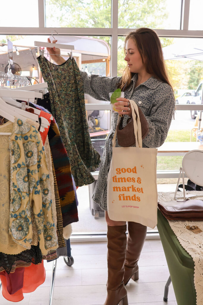 Shopper searching through vintage clothing rack
